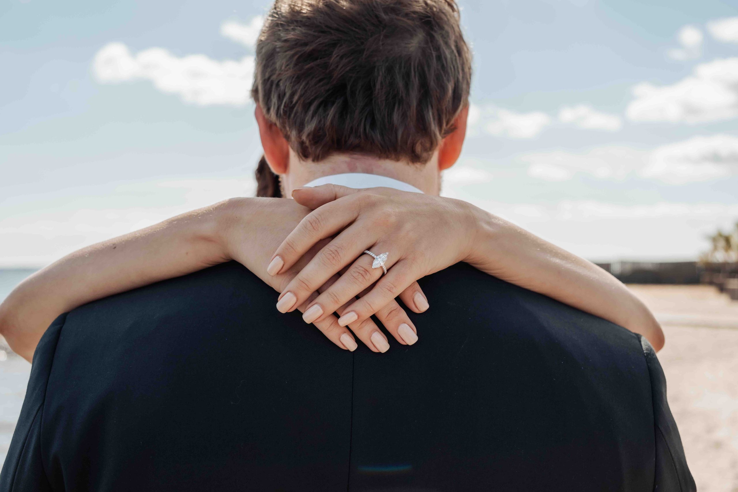 Wedding couple embracing by the beach